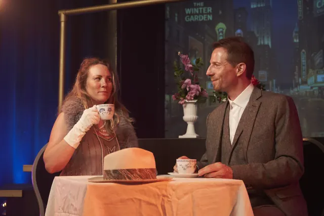 Ein Paar an einem gedeckten Tisch im Wintergarten